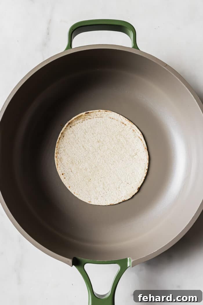 Flavor-Packed Homemade Chicken Tacos 8 A corn tortilla in the middle of a large skillet.