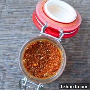 Jar of homemade taco seasoning in small spice jar, featuring the vibrant colors of the spices ready to be used in cooking.