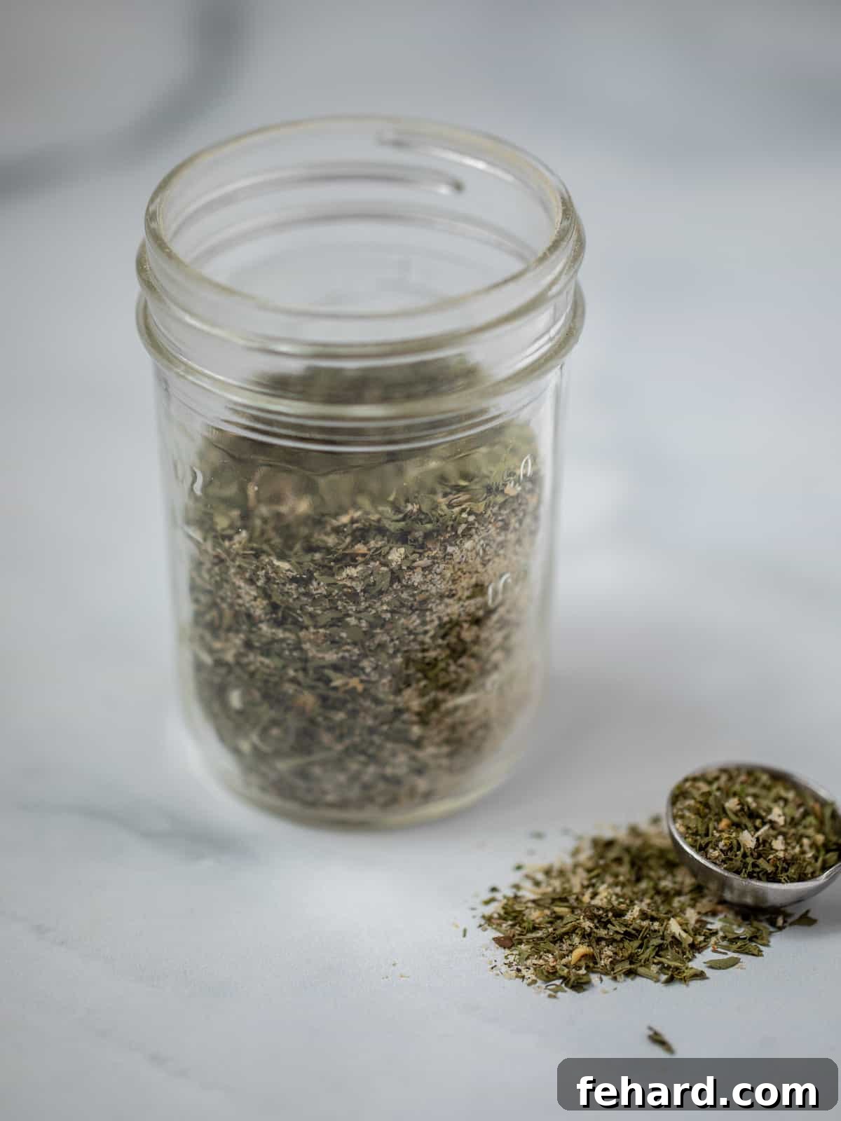 Homemade Ranch Seasoning Jar of homemade ranch seasoning blend on white counter.