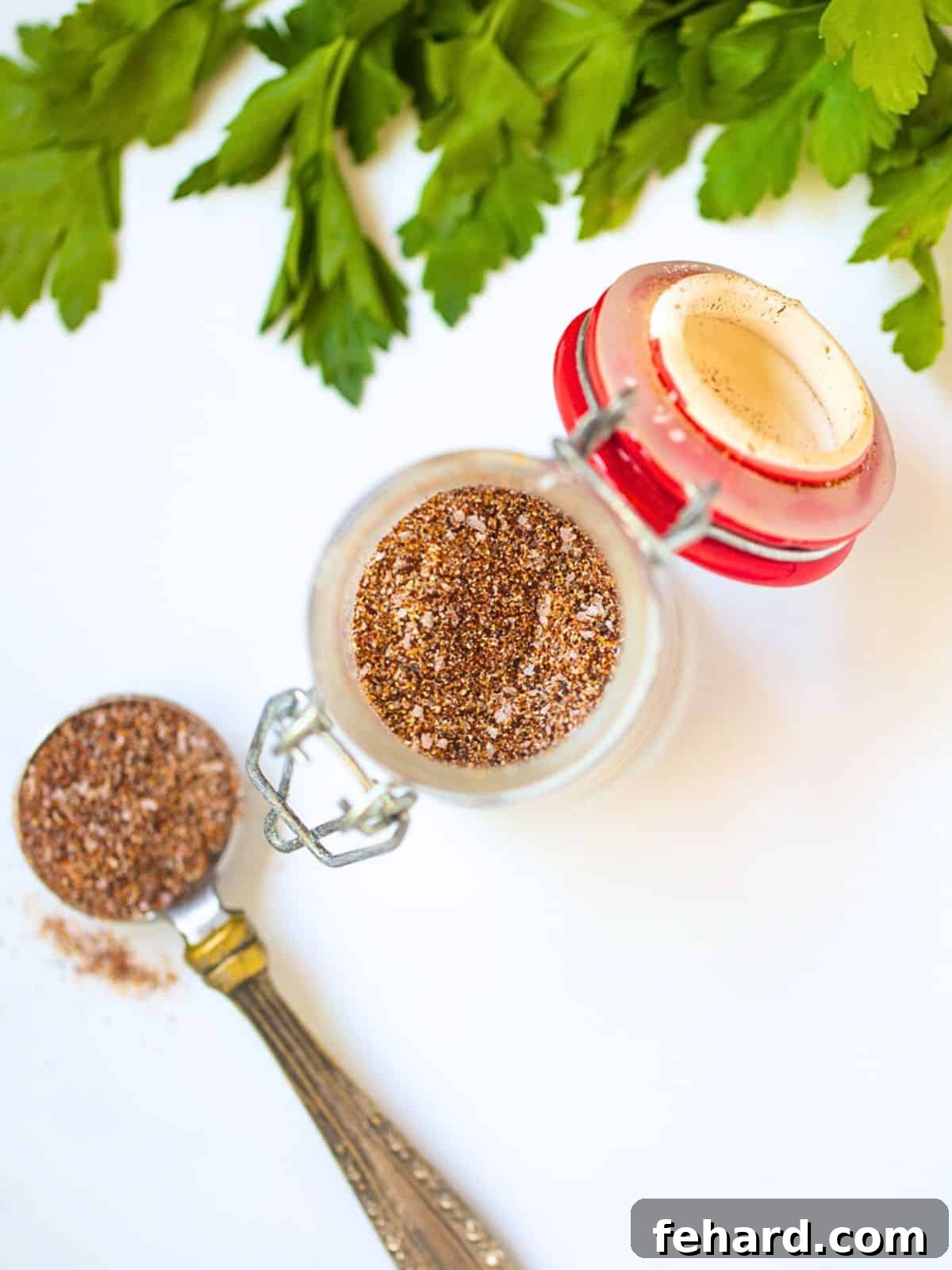 A small glass jar filled with vibrant homemade chili seasoning, showcasing the rich colors of chili powder, cumin, garlic powder, onion powder, salt, and a hint of cayenne. It represents the ultimate secret to flavorful chili.