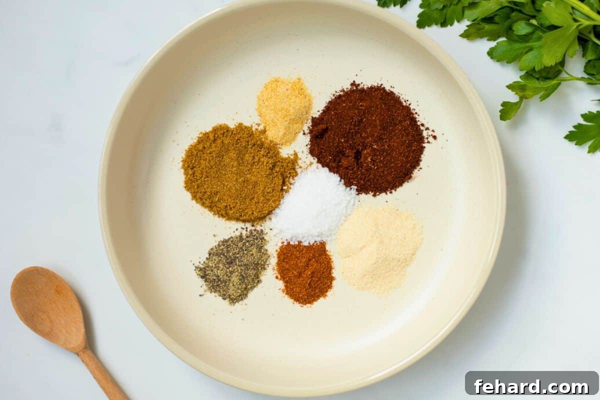 A beautiful array of spices for chili seasoning displayed in shallow bowls, featuring chili powder, cumin, paprika, garlic powder, and cayenne, ready to be blended into a flavorful mix.