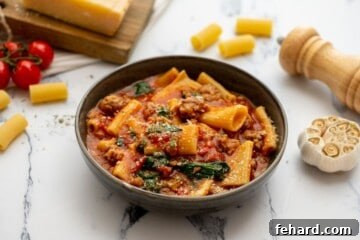 Bowl of Instant Pot Rigatoni with sausage topped with parmesan cheese.