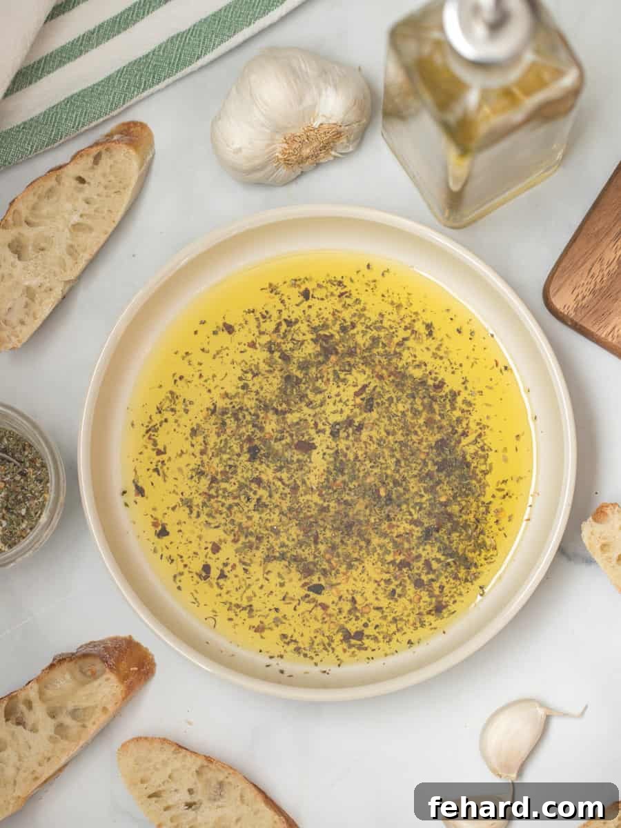 Dried Spices and olive oil in shallow serving bowl after mixing together next to sliced toasted bread.