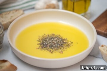 Dried Spices and olive oil in shallow serving bowl next to sliced toasted bread.