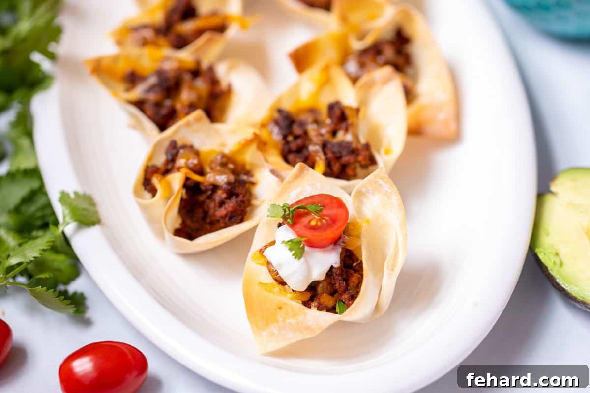 Mini Tacos On White Platter  that are topped with tomatoes and sour cream. 