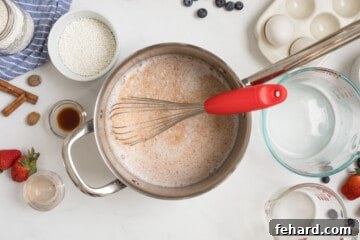 Small saucepan with milk, cream, cinnamon, nutmeg, and sugar whisked together.