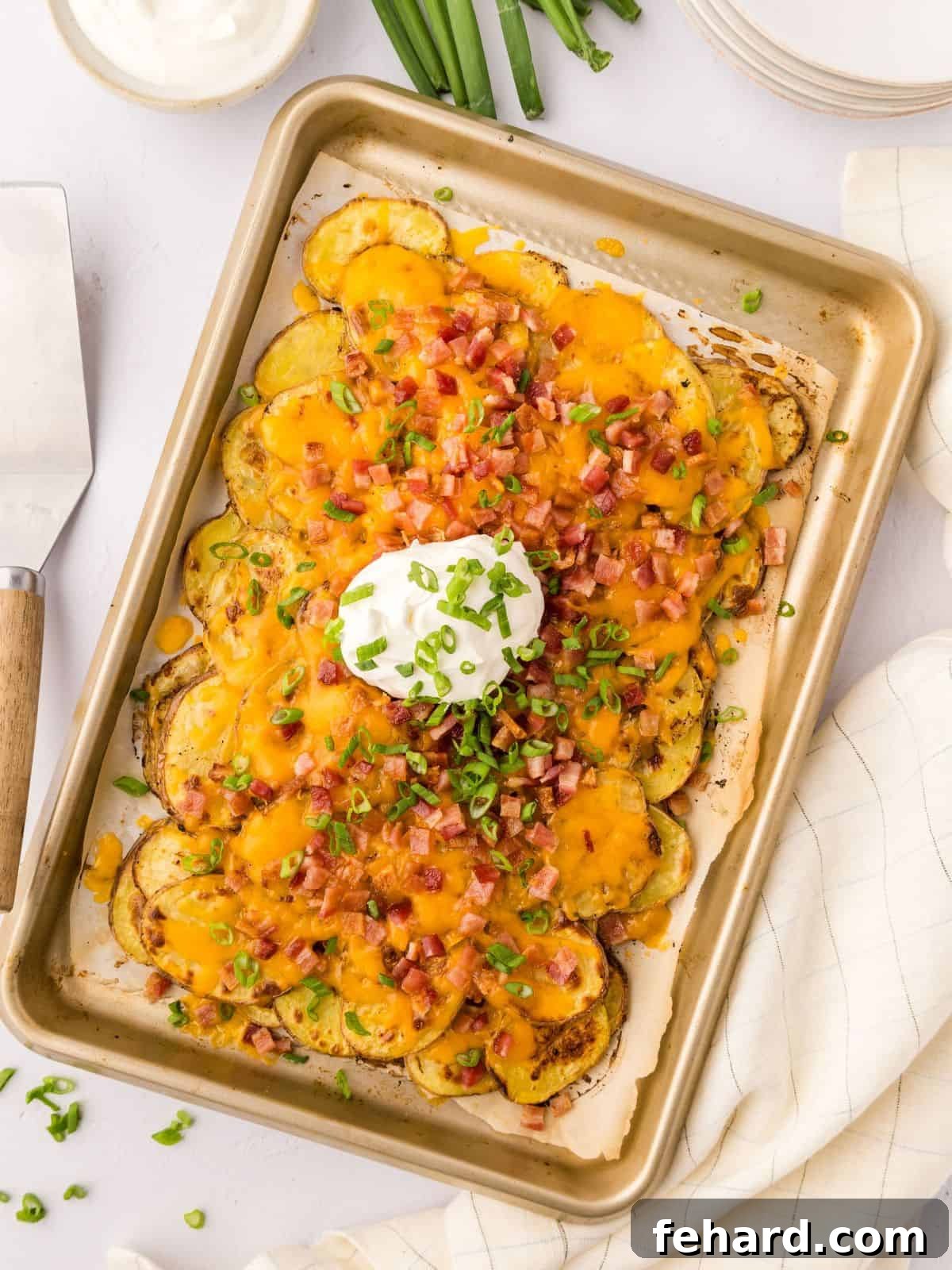 Crispy Irish Potato Nachos Loaded Irish Potato Nachos made with crispy baked potato slices topped with cheese and bacon on sheet pan topped with green onions and sour cream. A perfect game day appetizer.