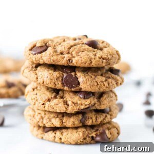 Five gluten-free chocolate chip cookies stacked on top of each other, ready to be enjoyed.