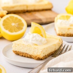 One lemon cheesecake bar on white plate topped with whipped cream and a lemon wedge.