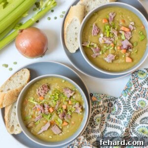 Two bowls of Instant Pot split pea soup topped with diced ham and carrots served next to crusty bread.