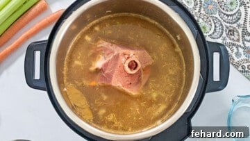 Hearty Instant Pot Split Pea Soup 5 Ingredients for split pea soup inside inner pot with ham bone.