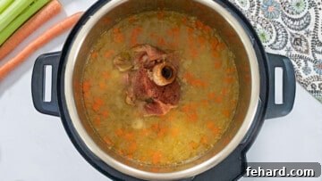 Hearty Instant Pot Split Pea Soup 6 Instant Pot Filled with cooked split peas in a rich broth with ham bone in the inner pot.