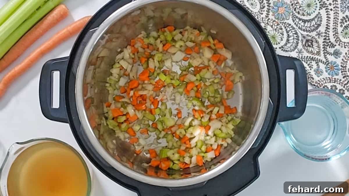 Sautéing Vegetables for Split Pea Soup Finely minced carrots, onions, and celery beautifully sautéed and softened in olive oil within the Instant Pot's inner pot, creating a fragrant base for the soup.