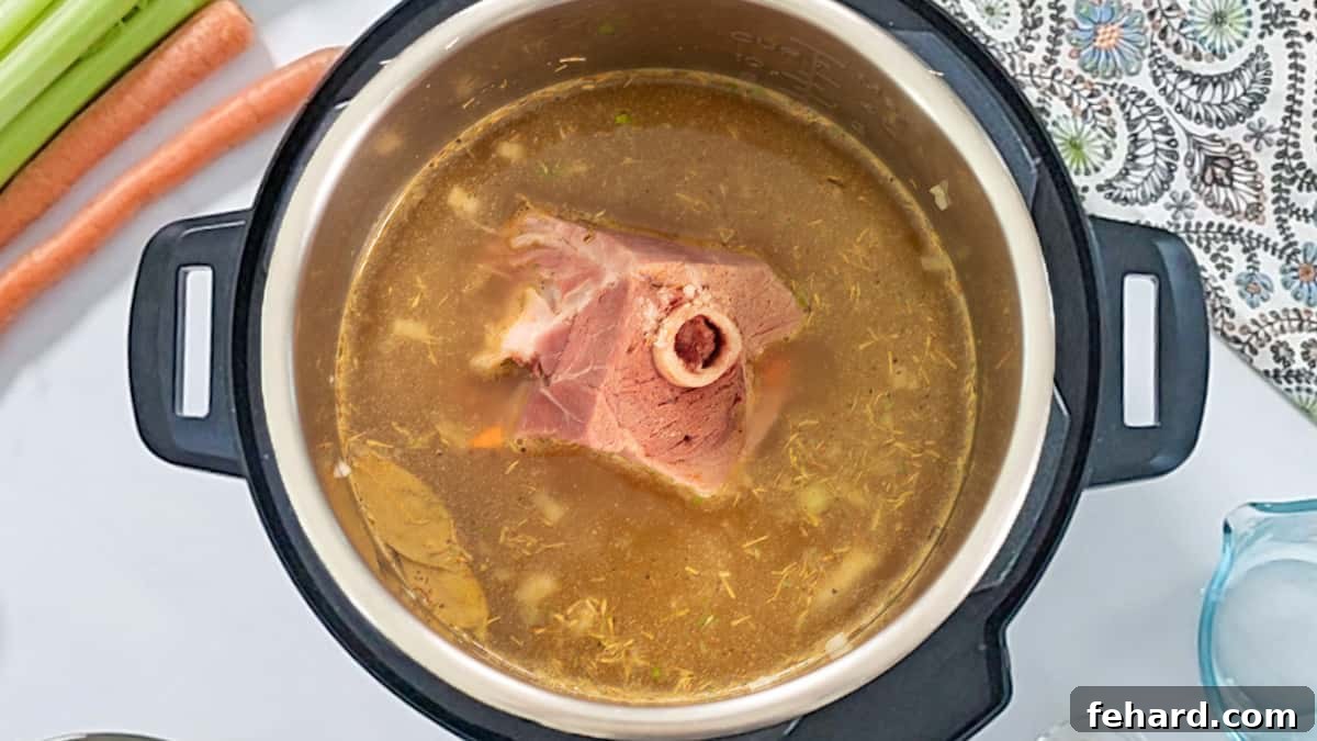 Layering Soup Ingredients in Instant Pot All the ingredients for split pea soup, including rinsed split peas, broth, seasonings, and a ham bone, carefully layered inside the Instant Pot's inner pot before cooking.