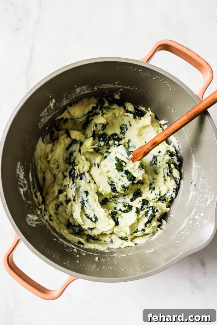 Irish Comfort Colcannon 7 Colcannon in a large pot with a wooden-handled spatula in it.