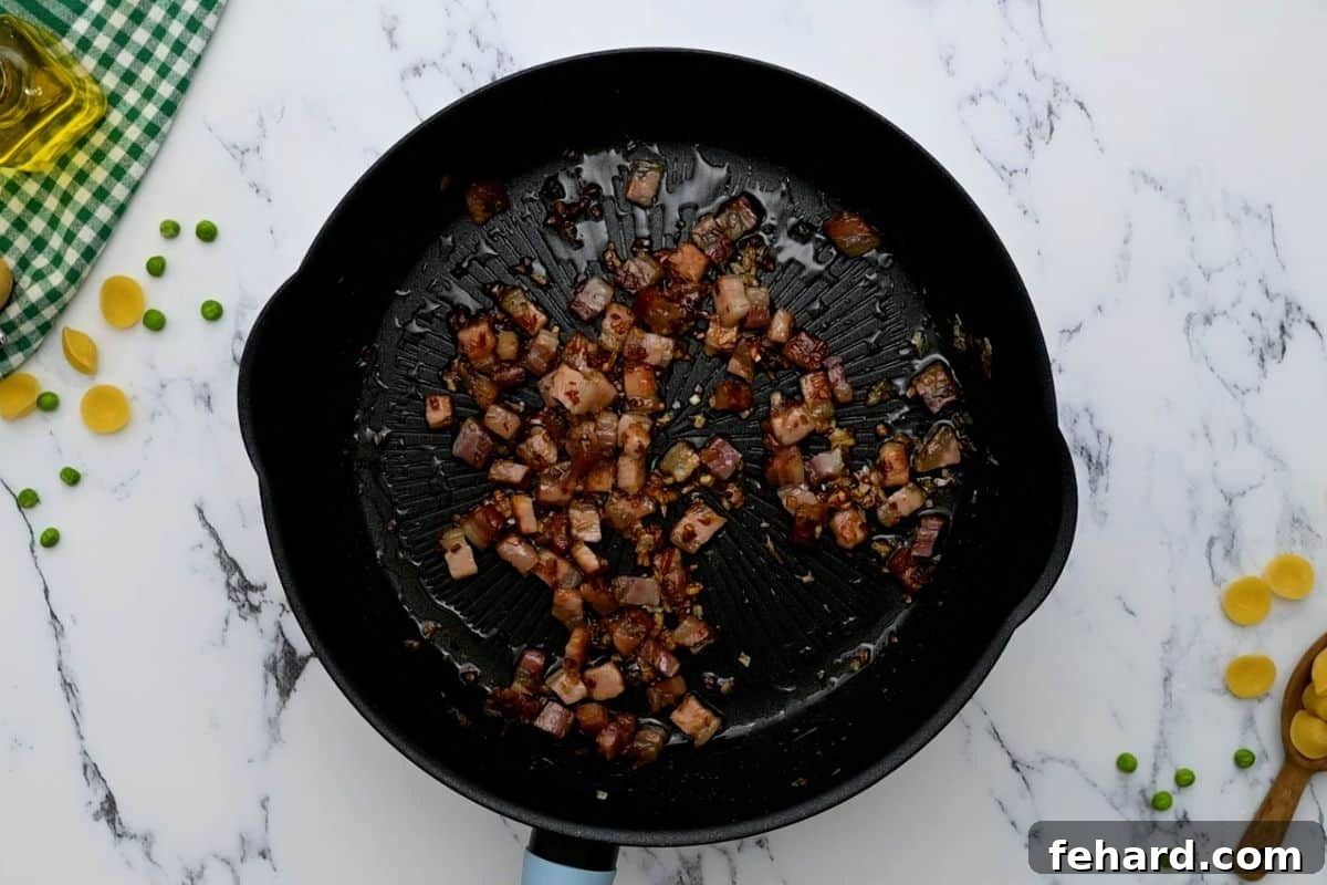 Sautéing Pancetta and Shallots Crispy pancetta and softened shallots sizzling in a sauté pan after being cooked together, with rendered fat glistening in the pan.