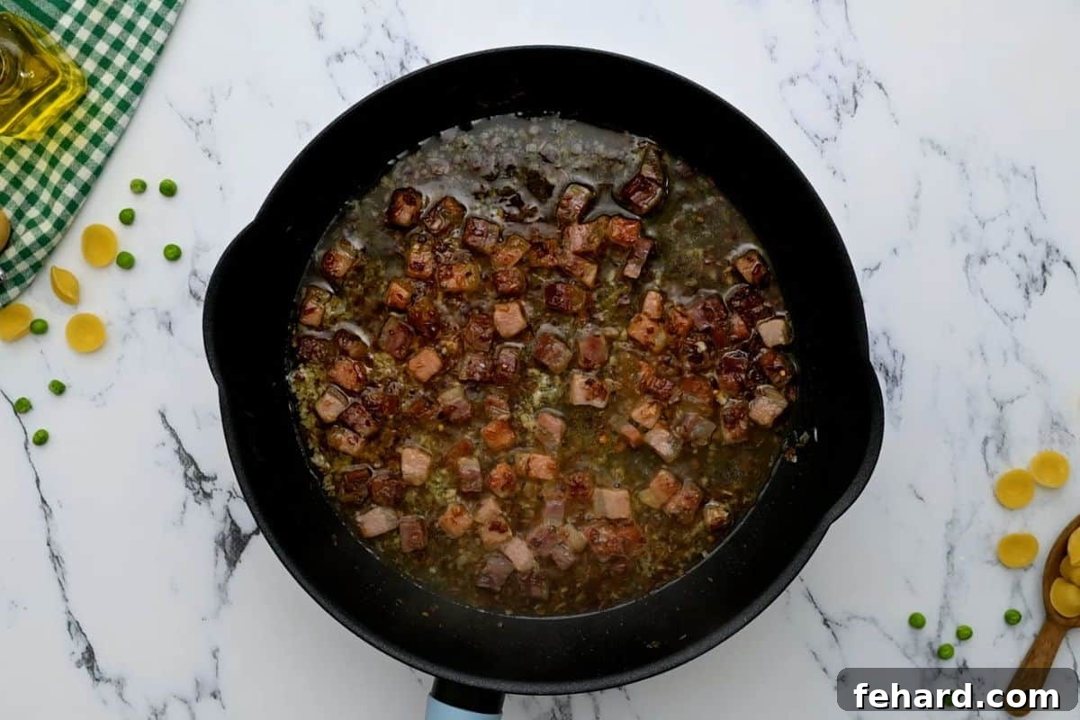 Deglazing with White Wine Pancetta and shallots in a sauté pan, now glistening after being deglazed with white wine, creating a rich flavorful base.