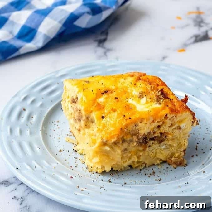 Leftover Ham Hashbrown Casserole A generous slice of a cheesy egg and hashbrown breakfast casserole with sausage.