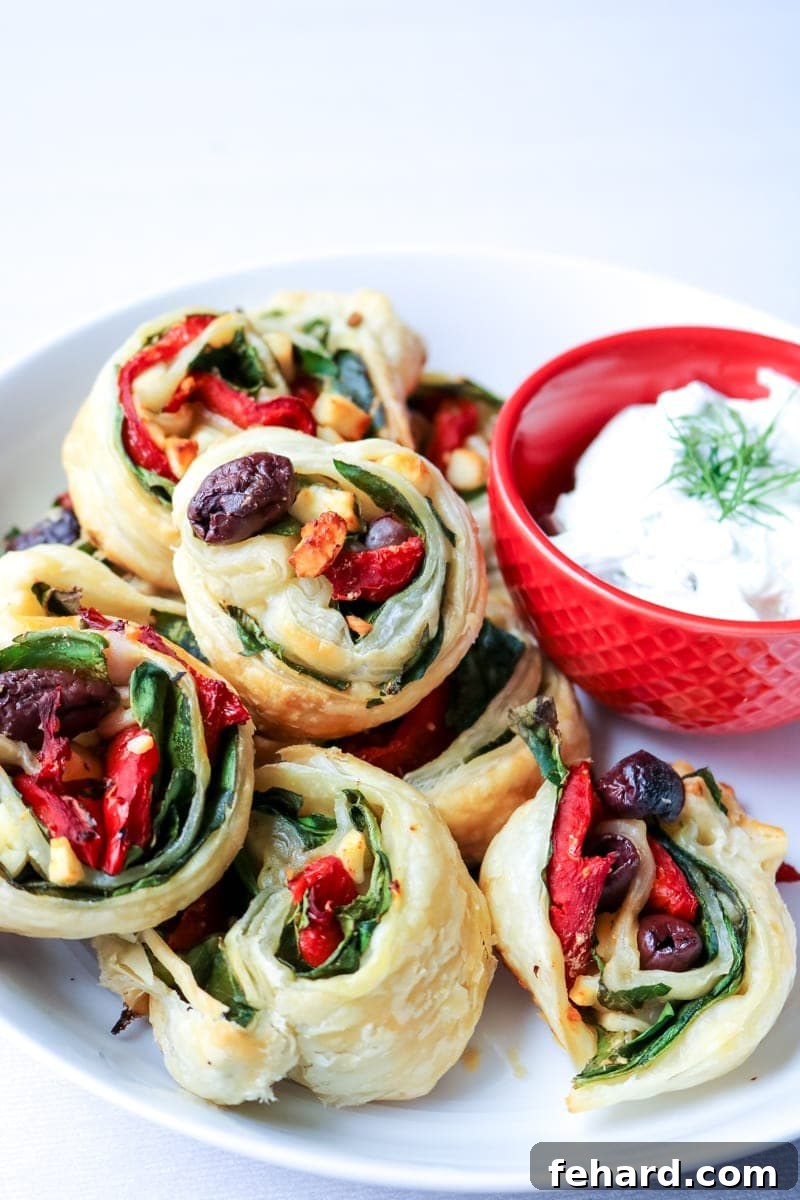 Elegant Greek Pinwheels Appetizer Plate of golden-baked Greek Pinwheels, showcasing their flaky crust and savory filling.