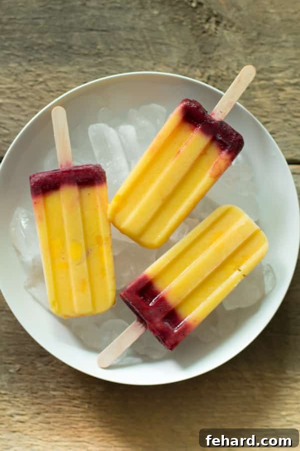 Mango Plum Popsicle standing upright on a white surface, showcasing its vibrant colors