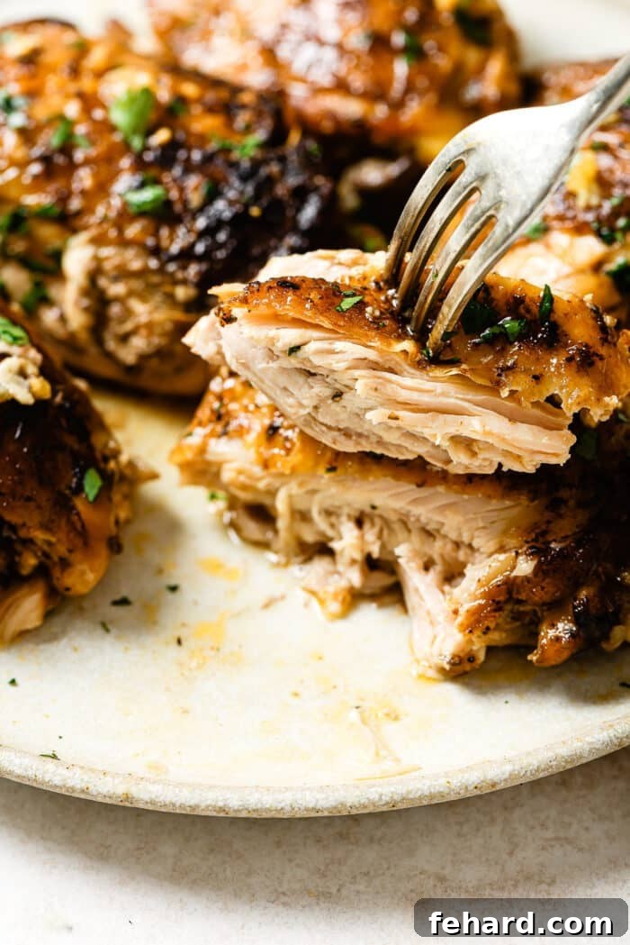 A fork picking up a slice of slow cooker chicken thighs. 