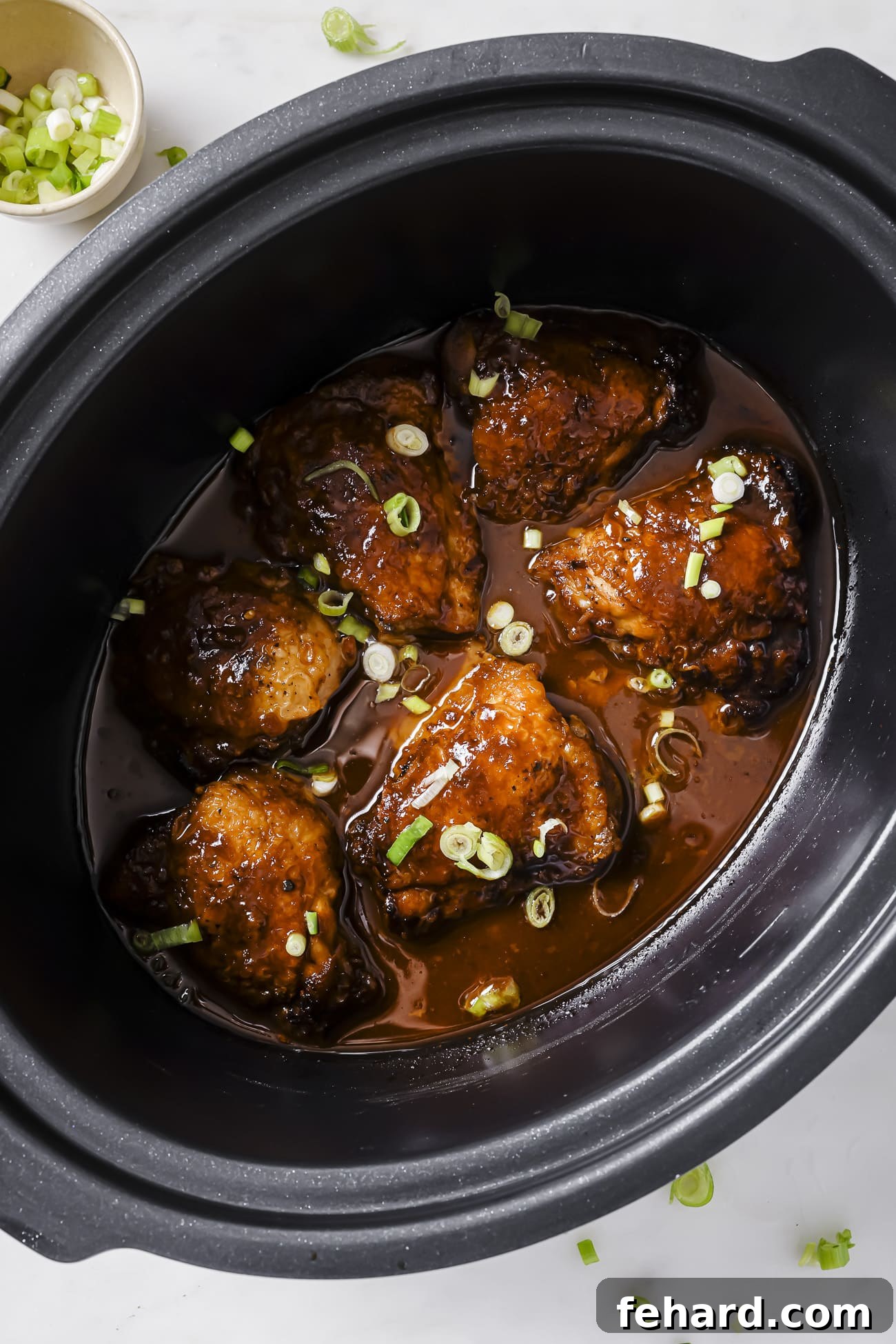 Sweet & Sticky Slow Cooker Chicken 6 Chicken thighs in the slow cooker with sliced green onions.