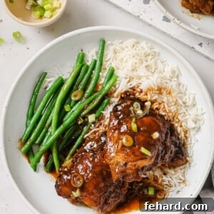 Sweet & Sticky Slow Cooker Chicken 8 Slow Cooker chicken thighs on a white plate with green beans and rice.