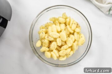 Bowl with potato gnocchi seasoned with olive oil, garlic powder, parmesan, and oregano.