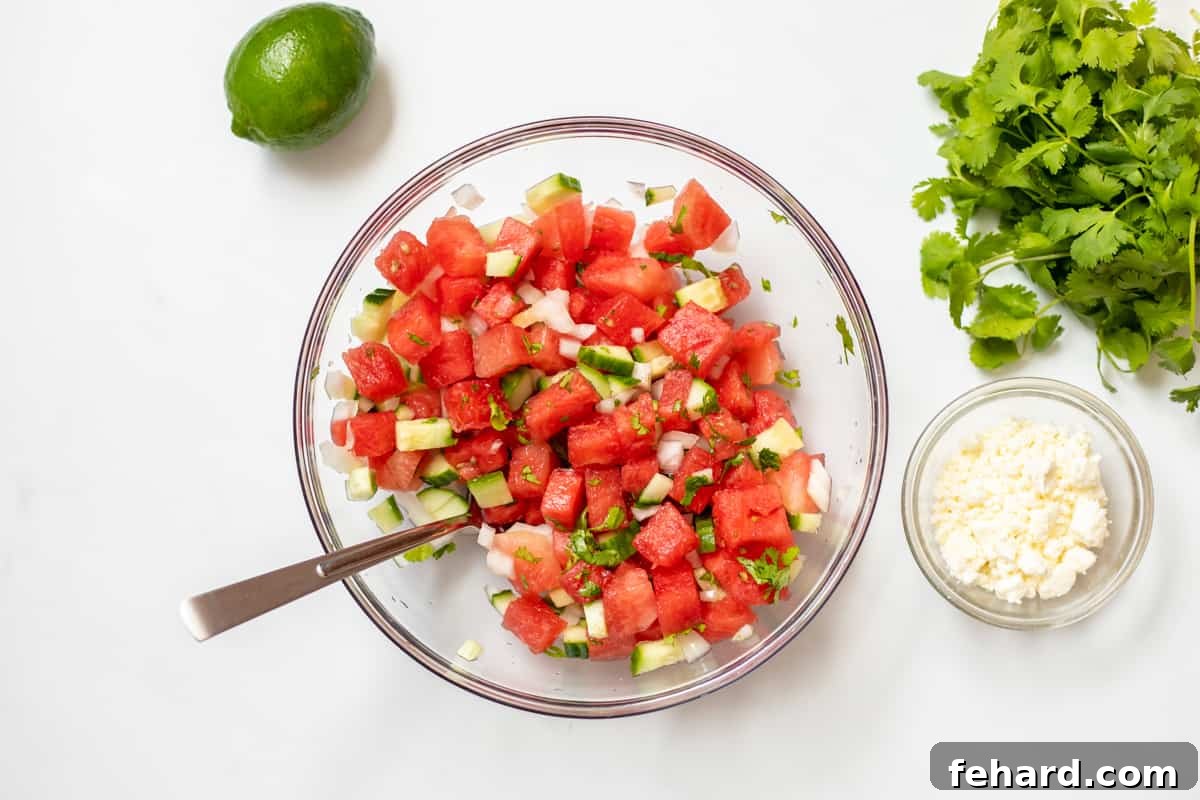 Mixing bowl with watermelon cucumber salsa after mixing with onion and cilantro.