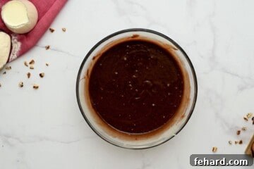 Smooth batter for Texas Sheet cake in a clear mixing bowl, showcasing its rich texture.