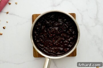 Saucepan filled with the luscious chocolate frosting after stirring in powdered sugar and nuts, ready to top the cake.