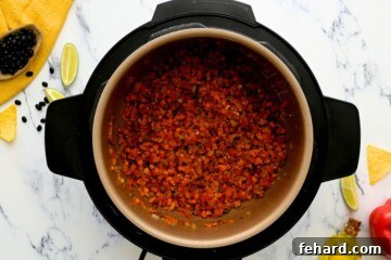 Delicious Instant Pot Black Bean Soup 2 Carrots, jalapenos, onions, and peppers sauteed in inner pot with cumin and paprika.