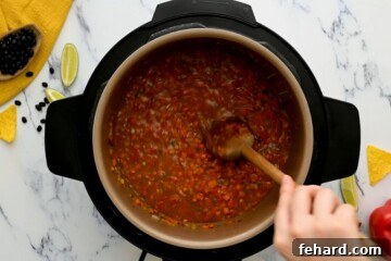 Delicious Instant Pot Black Bean Soup 3 Wooden spoon scraping up bottom of inner pot after adding water.