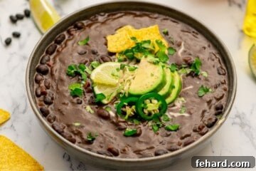 Delicious Instant Pot Black Bean Soup 7 Bowl of Pressure Cooked Black Bean soup topped with cilantro, avocado, and sliced jalapeno.