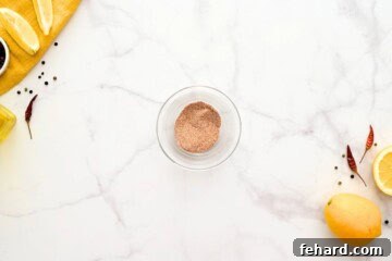 Dry spices being mixed together in a small bowl, forming the flavorful rub for the air fryer shrimp.