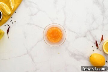 A small bowl containing a mixture of honey, minced garlic, hot sauce, and fresh lemon juice, ready for the glaze.