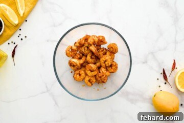 Air-fried shrimp, now coated in a luscious honey-lemon glaze, tossed in a bowl ready for serving.
