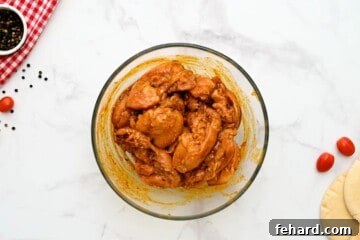 Chicken thighs in chicken shawarma marinade in large mixing bowl.