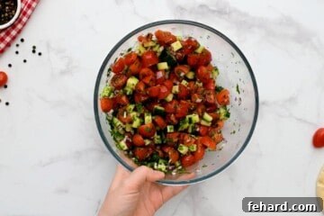 Tomatoes, cucumber, red onions, and parsley combined in small mixing bowl.