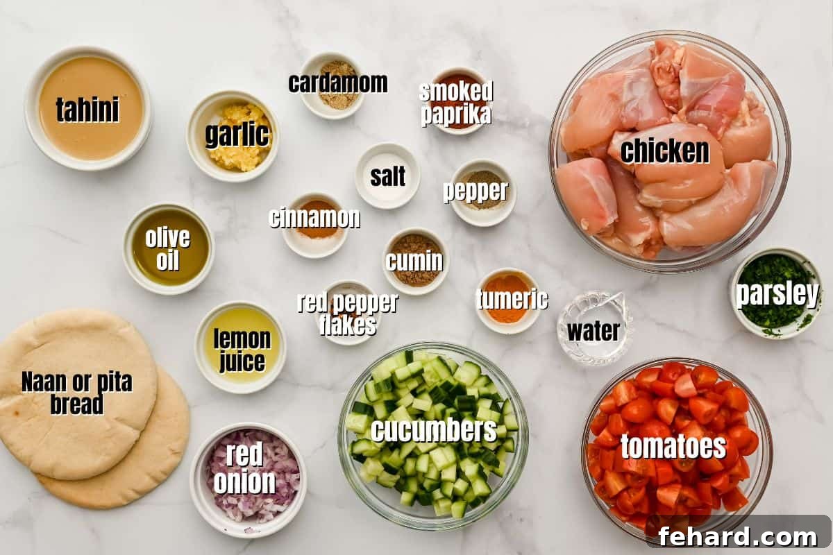 Array of fresh ingredients for Chicken Shawarma wraps, including spices, lemon, tahini, cucumber, tomatoes, and chicken, neatly arranged on a counter.