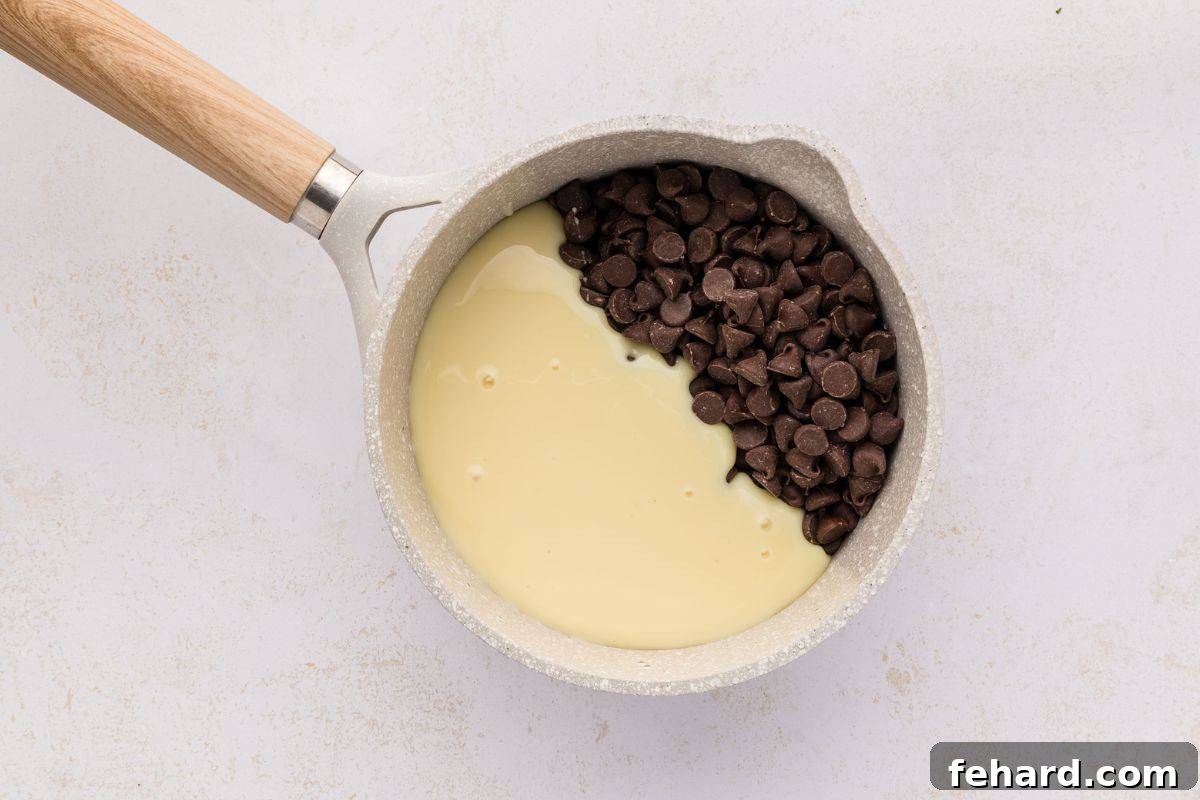 How to Make Homemade Hot Fudge Semi-sweet chocolate chips melting into sweetened condensed milk in a small saucepan.