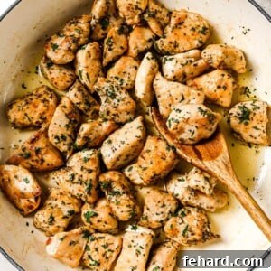 Appetizing Garlic Butter Chicken Bites in a skillet, garnished with fresh herbs.