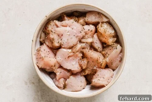 Seasoned raw chicken in a white bowl