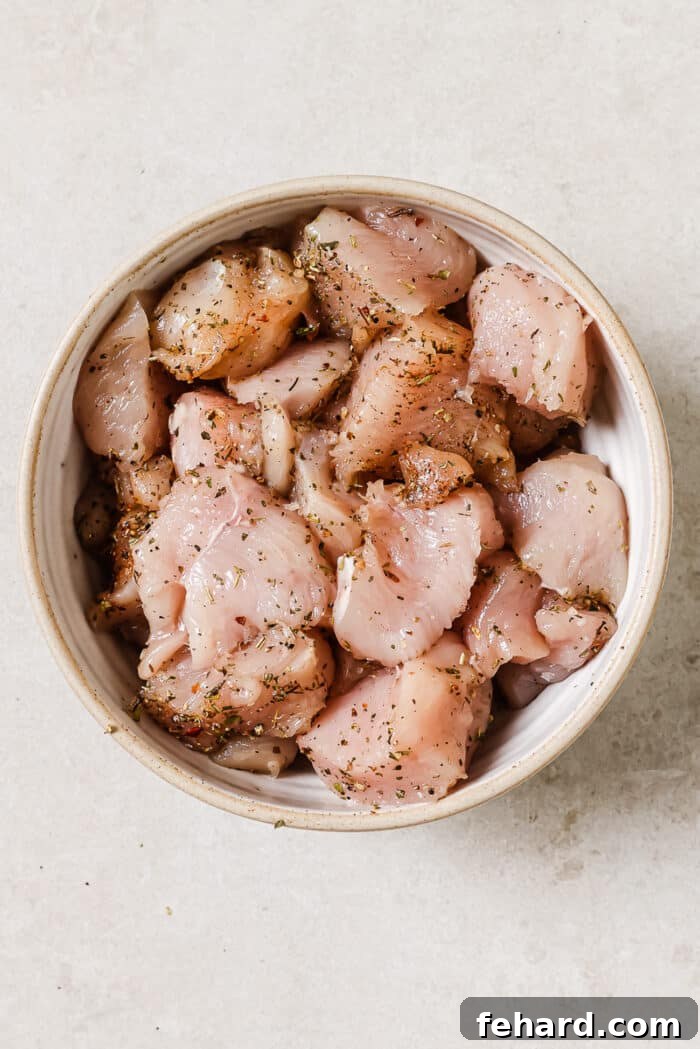 Seasoned raw chicken in a white bowl