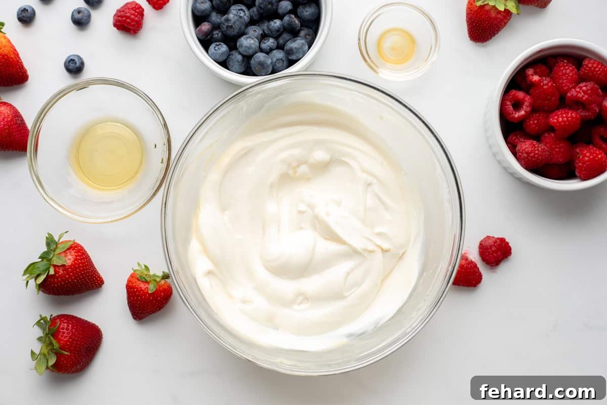 Healthy Yogurt Bark Base Yogurt mixed with maple syrup and vanilla mixed together in clear mixing bowl.