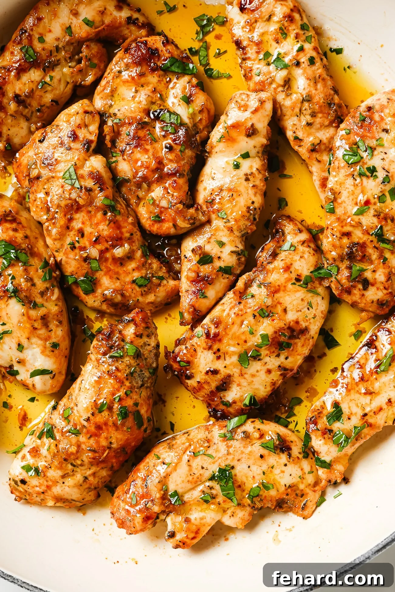 Garlic butter chicken tenders garnished with fresh parsley.