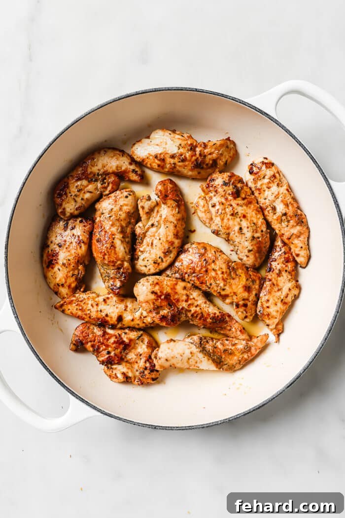Cooked chicken tenders in a large ceramic cast-iron skillet. 