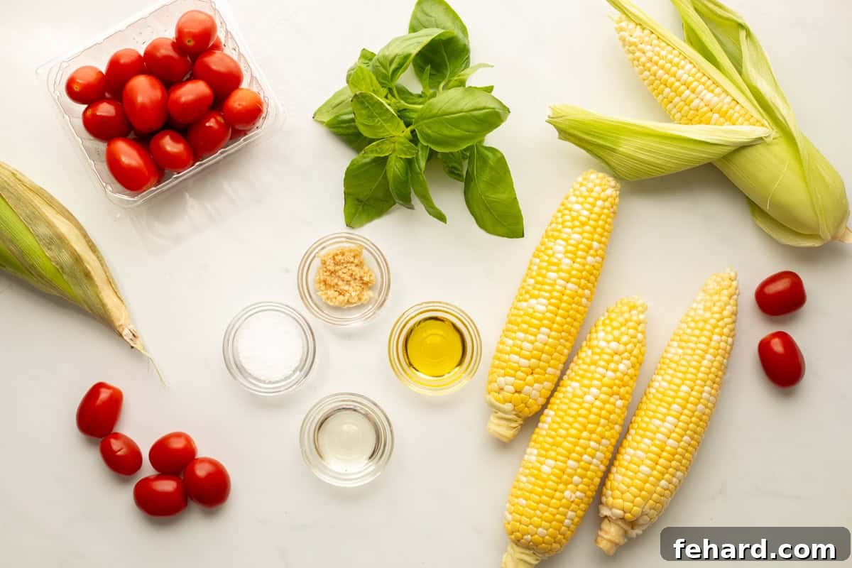 Fresh ingredients laid out on a kitchen counter: ears of corn, ripe grape tomatoes, fresh basil leaves, a bottle of olive oil, and a bottle of white wine vinegar, ready for making corn and tomato salad.