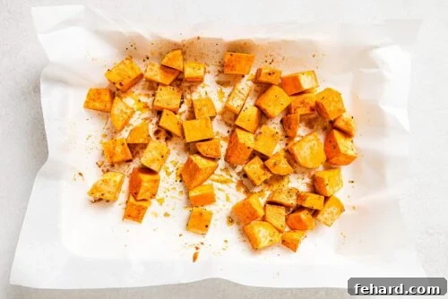 raw diced sweet potato on a baking sheet.