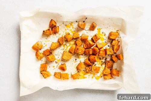 cooked diced sweet potato on a baking sheet.